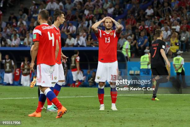 Sergey Ignashevich, Ilya Kutepov and Fedor Kudriashov of Russia look dejected following Croatia second goal during the 2018 FIFA World Cup Russia...