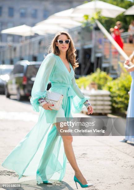 Alexandra Lapp wearing a long shine through dress in turquoise by Lana Mueller, a 2.55 silver handbag by Chanel, two tone Mahnolo Blahnik heels in...