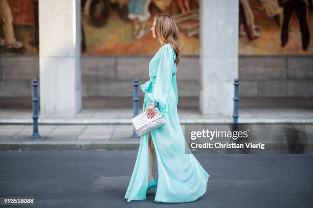 Alexandra Lapp wearing a long shine through dress in turquoise by Lana Mueller, a 2.55 silver handbag by Chanel, two tone Mahnolo Blahnik heels in...