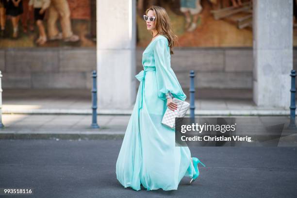 Alexandra Lapp wearing a long shine through dress in turquoise by Lana Mueller, a 2.55 silver handbag by Chanel, two tone Mahnolo Blahnik heels in...