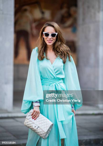 Alexandra Lapp wearing a long shine through dress in turquoise by Lana Mueller, a 2.55 silver handbag by Chanel, two tone Mahnolo Blahnik heels in...