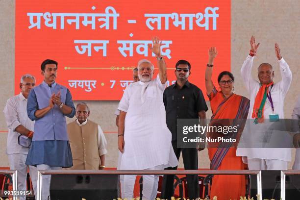 Prime Minister Narendra Modi with Rajasthan Chief Minister Vasundhara Raje waves during a public meeting for the beneficiaries of various welfare...