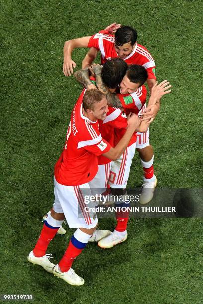 Russia's defender Mario Fernandes is congratulated by teammates after scoring a goal during the Russia 2018 World Cup quarter-final football match...