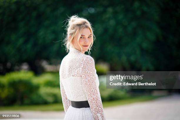 Karlie Kloss wears a white lace dress , outside Dior, during Paris Fashion Week Haute Couture Fall Winter 2018/2019, on July 2, 2018 in Paris, France.