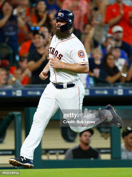 Evan Gattis of the Houston Astros scores in the second inning on a double by Max Stassi against the Chicago White Sox at Minute Maid Park on July 7,...