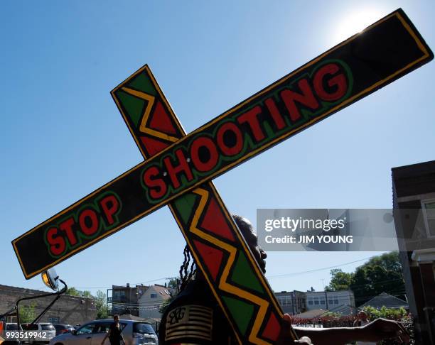 Demonstrator carrying a cross heads to an anti-violence protest on the Dan Ryan Expressway in Chicago, July 7, 2018. - Thousands of protesters...