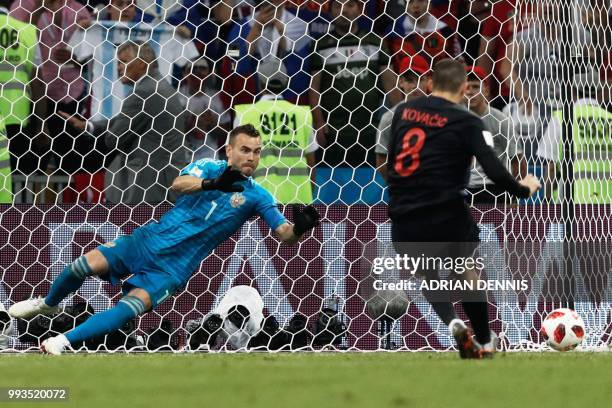 Russia's goalkeeper Igor Akinfeev dives to save a penalty from Croatia's midfielder Mateo Kovacic during the Russia 2018 World Cup quarter-final...