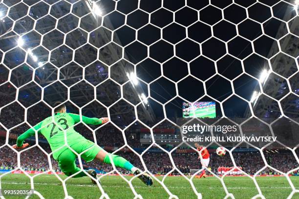 Croatia's goalkeeper Danijel Subasic fails to stop Russia's defender Sergey Ignashevich's shot during the penalty shootout during the Russia 2018...