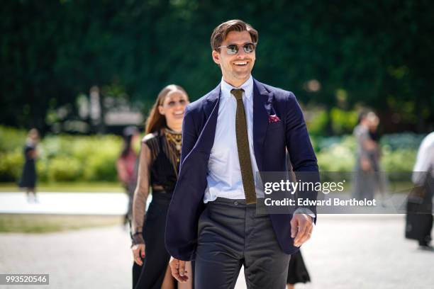 Johannes Huebl wears a shirt, a tie, a blue blazer jacket, sunglasses , outside Dior, during Paris Fashion Week Haute Couture Fall Winter 2018/2019,...