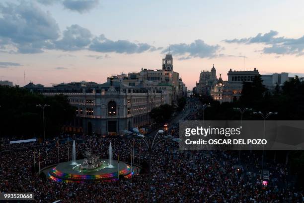 Revellers take part in the Gay Pride 2018 parade at the Cibeles square illuminated with the colors of the rainbow flag in Madrid, on July 7 one of...