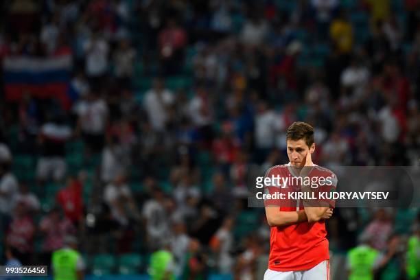 Russia's midfielder Daler Kuzyaev reacts after the team lost the Russia 2018 World Cup quarter-final football match between Russia and Croatia at the...