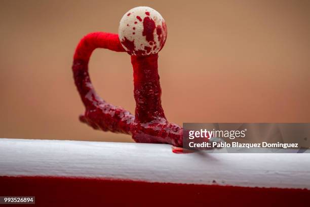 Sword with blood holds the wall of the bullring after a bull was killed during a bullfight on the second day of the San Fermin Running of the Bulls...