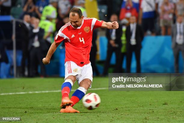 Russia's defender Sergey Ignashevich shoots to score his penalty during the Russia 2018 World Cup quarter-final football match between Russia and...
