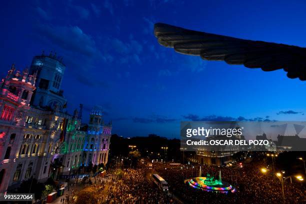 Revellers take part in the Gay Pride 2018 parade at the Cibeles square illuminated with the colors of the rainbow flag in Madrid, on July 7 one of...
