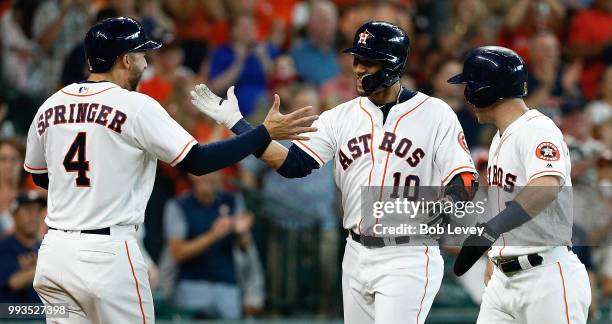 Yuli Gurriel of the Houston Astros celebrates with Alex Bregman and George Springer after hitting a three-run home run in the third inning against...