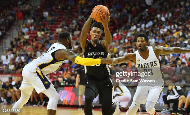 Lonnie Walker IV of the San Antonio Spurs drives against Travis Leslie and CJ Wilcox of the Indiana Pacers during the 2018 NBA Summer League at the...