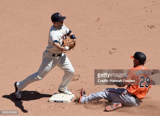 Jace Peterson of the Baltimore Orioles is out at second base as Brian Dozier of the Minnesota Twins turns a double play during the seventh inning of...