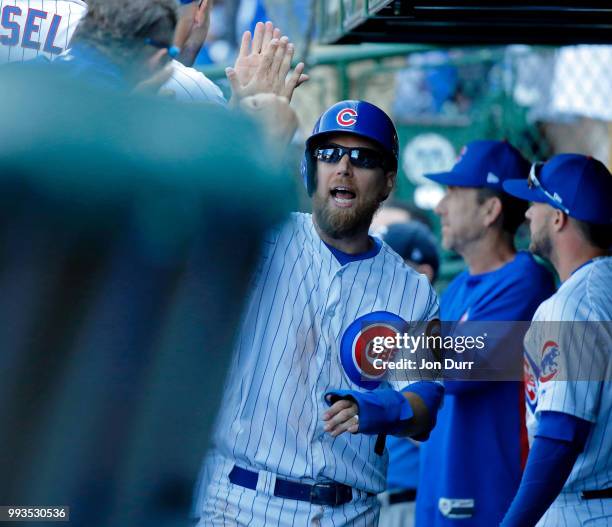 Ben Zobrist of the Chicago Cubs is congratulated in the dugout after scoring against the Cincinnati Reds during the eighth inning at Wrigley Field on...