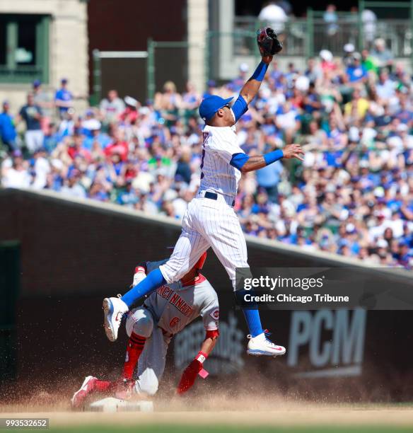 The Cincinnati Reds' Billy Hamilton steals second base under Chicago Cubs shortstop Addison Russell during the eighth inning at Wrigley Field in...