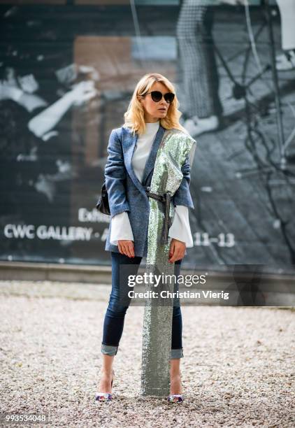 Gitta Banko wearing a dark-blue, checked alpaca tweed blazer, white silk blouse, and silver sequin scarf by Agnona, dark blue jeans by Citizens of...