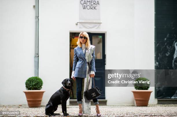 Gitta Banko wearing a dark-blue, checked alpaca tweed blazer, white silk blouse, and silver sequin scarf by Agnona, dark blue jeans by Citizens of...