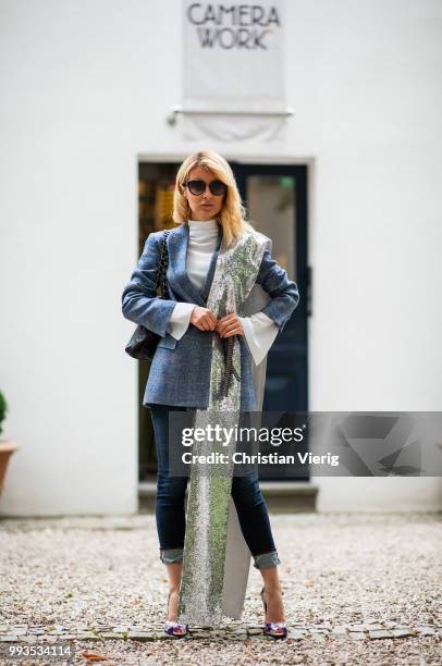 Gitta Banko wearing a dark-blue, checked alpaca tweed blazer, white silk blouse, and silver sequin scarf by Agnona, dark blue jeans by Citizens of...