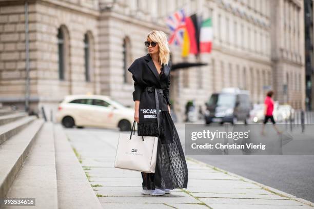 Gitta Banko wearing black lace bra by Anine Bing, black lace skirt by Jadicted, black blazer by Helmut Lang, black statement scarf and grey-black...