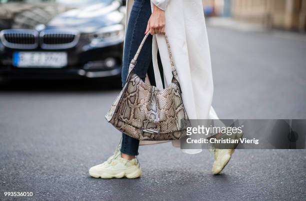 Lisa Hahnbueck wearing white coat Max Mara, olive cropped top Urban Outfitters, dark blue Re/done Levis jeans, Yeezy 500 Adidas sneakers, Tods bag...