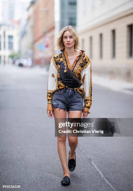 Lisa Hahnbueck wearing silk blouse with print Versace, Versace fanny belt bag , Levis 501 shorts, Tods loafer during the Berlin Fashion Week July...