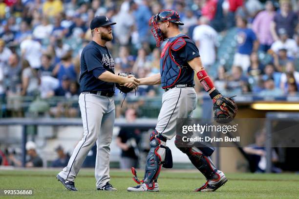 Minter and Tyler Flowers of the Atlanta Braves celebrate after beating the Milwaukee Brewers 5-1 at Miller Park on July 7, 2018 in Milwaukee,...