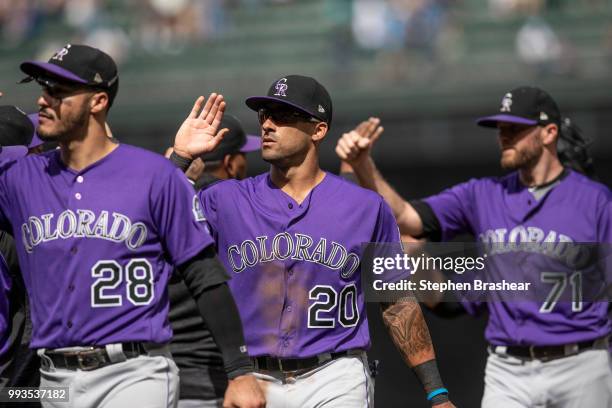 Nolan Arenado of the Colorado Rockies, Ian Desmond and Wade Davis celebrater after a game against the Seattle Mariners at Safeco Field on July 7,...