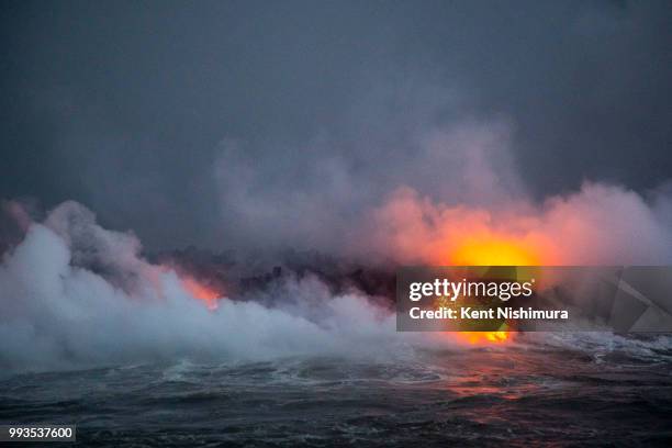People aboard Lava Ocean Tour's boat, "Hot Shot," off shore of what used to be Kapoho Bay, watch as lava flows into the ocean after traveling down...