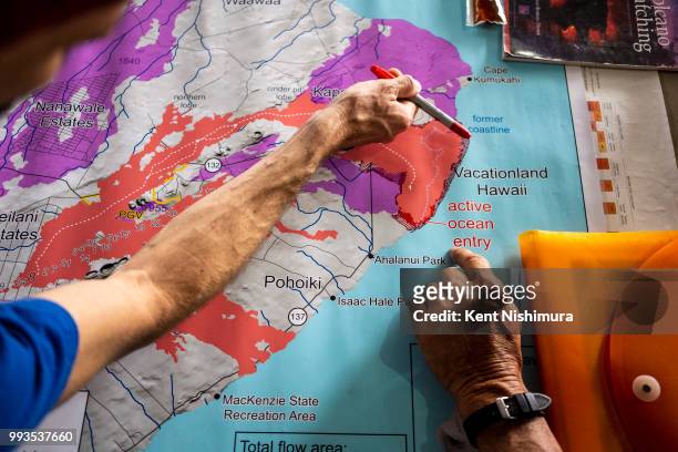 John Stallman from Orchidland, Hilo, HI points to areas where lava has expanded the coast of Hawaii Island, while talking with Kalapana resident...