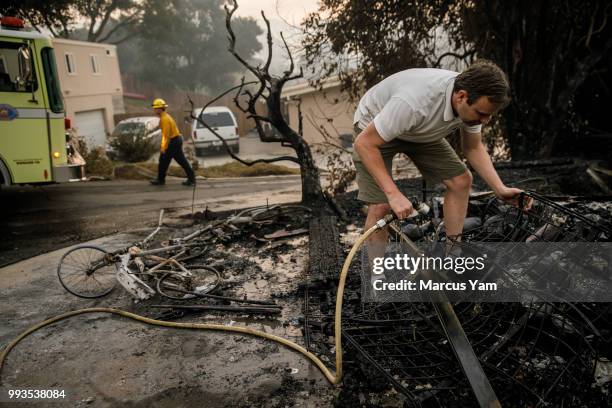 Eric Durtschi searches through the rubble for personal belongings after his home was destroyed by wildfire, in Goleta, Calif., on July 7, 2018.