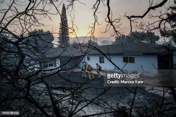 Firefighters try to contain an internal structure fire after wildfire swept through the neighborhood of N. Fairview ave, in Goleta, Calif., on July...