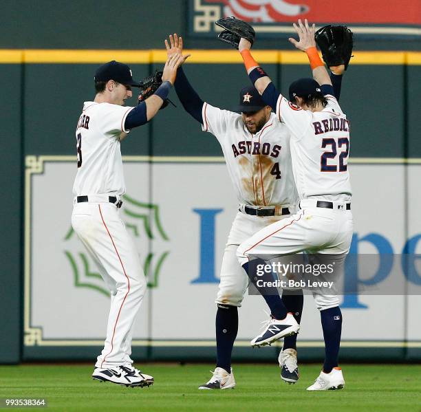 Kyle Tucker of the Houston Astros celebrates with George Springer and Josh Reddick after the final out against the Chicago White Sox at Minute Maid...