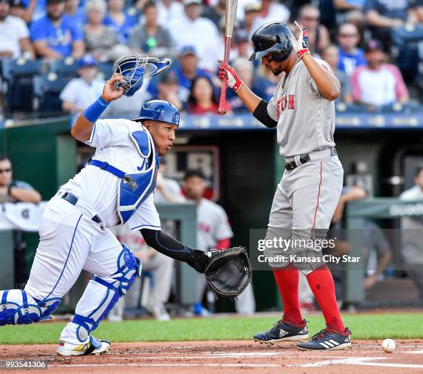 Kansas City Royals catcher Salvador Perez, left, picks up a dropped strike in front of the Boston Red Sox's Xander Bogaerts, before throwing Andrew...
