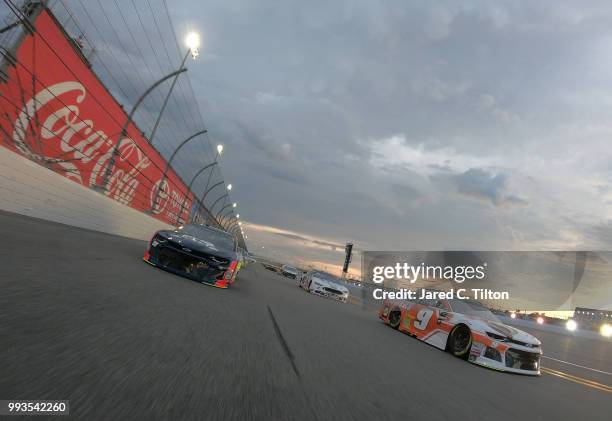 Chase Elliott, driver of the Hooters Chevrolet, and Alex Bowman, driver of the Axalta Chevrolet race the pace lap prior to the start of the Monster...