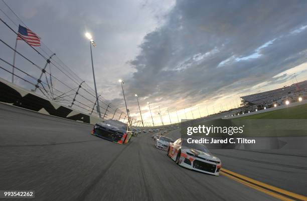Chase Elliott, driver of the Hooters Chevrolet, and Alex Bowman, driver of the Axalta Chevrolet race the pace lap prior to the start of the Monster...