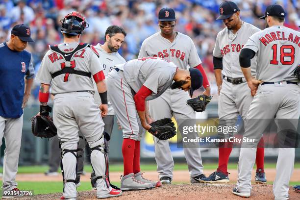 Boston Red Sox starting pitcher David Price is checked on after an RBI single by Kansas City Royals' Mike Moustakas bounced off him in the third...