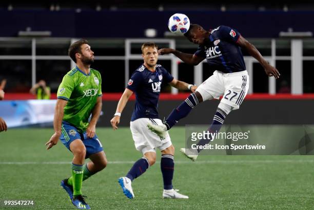 New England Revolution midfielder Luis Caicedo heads the ball away from Seattle Sounders FC forward Will Bruin during a match between the New England...