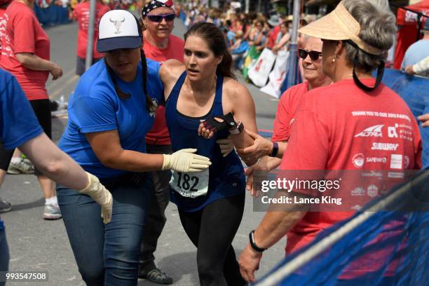 Jordin Thompson receives assistance following her race during the Women's Division of the 91st Running of the Mount Marathon Race on July 4, 2018 in...