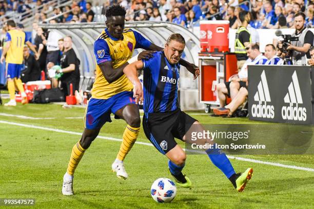 Colorado Rapids forward Dominique Badji holds onto Montreal Impact midfielder Samuel Piette while they both chase the ball during the Colorado Rapids...