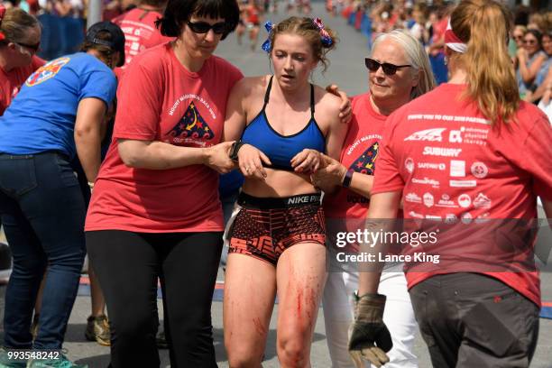 Kaylee Heck receives assistance following her race during the Women's Division of the 91st Running of the Mount Marathon Race on July 4, 2018 in...