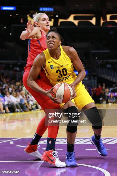 Nneka Ogwumike of the Los Angeles Sparks handles the ball against Elena Delle Donne of the Washington Mystics during a WNBA basketball game at...