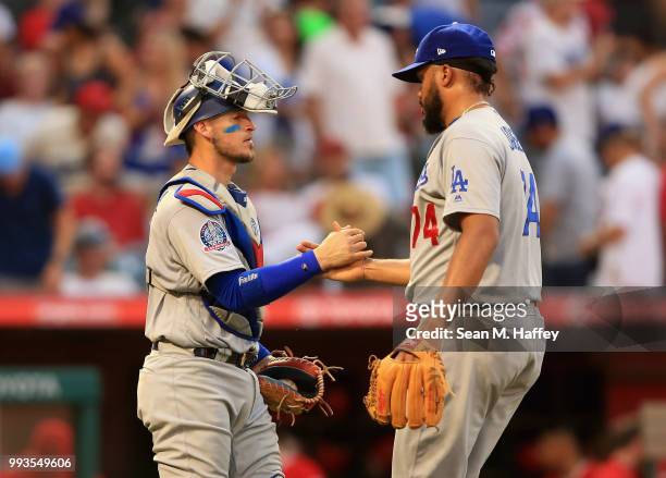 Yasmani Grandal congratulates Kenley Jansen of the Los Angeles Dodgers after defeating the Los Angeles Angels of Anaheim 3-1 in a game at Angel...