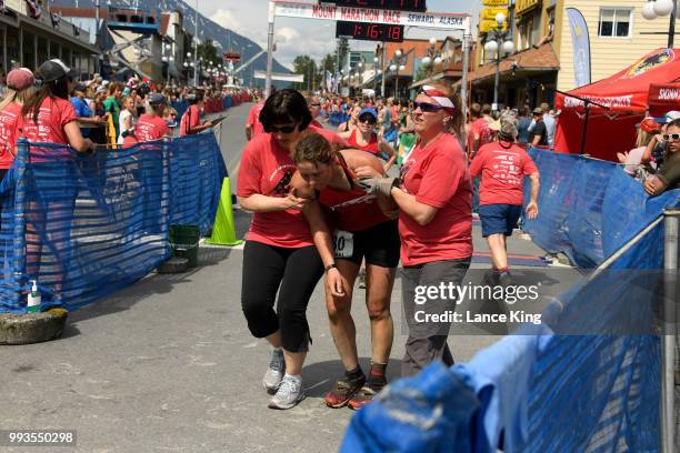 Laurel DeVore receives assistance following her race during the Women's Division of the 91st Running of the Mount Marathon Race on July 4, 2018 in...