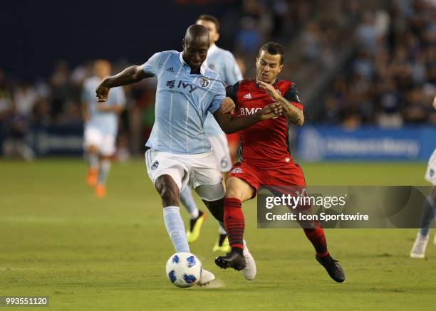 Sporting Kansas City defender Ike Opara and Toronto FC forward Sebastian Giovinco fight for the ball in the second half of an MLS match between...