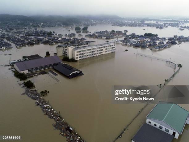 Photo taken from a drone on July 7 shows Makibi Higashi Junior High School in Kurashiki, Okayama Prefecture, submerged in flood waters following...