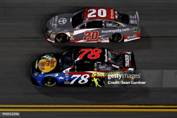 Martin Truex Jr., driver of the Bass Pro Shops/5-hour ENERGY Toyota, and Erik Jones, driver of the buyatoyota.com Toyota, race during the Monster...